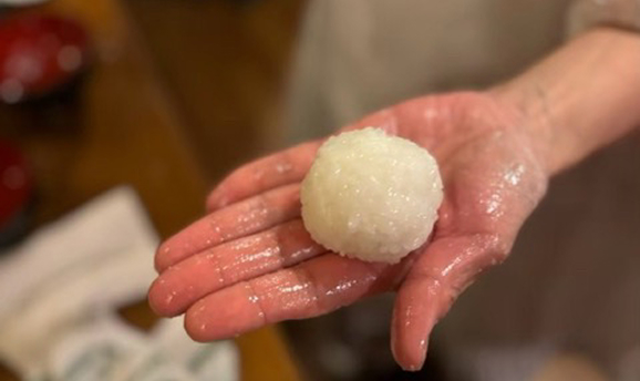 おむすびを手のひらに載せている写真